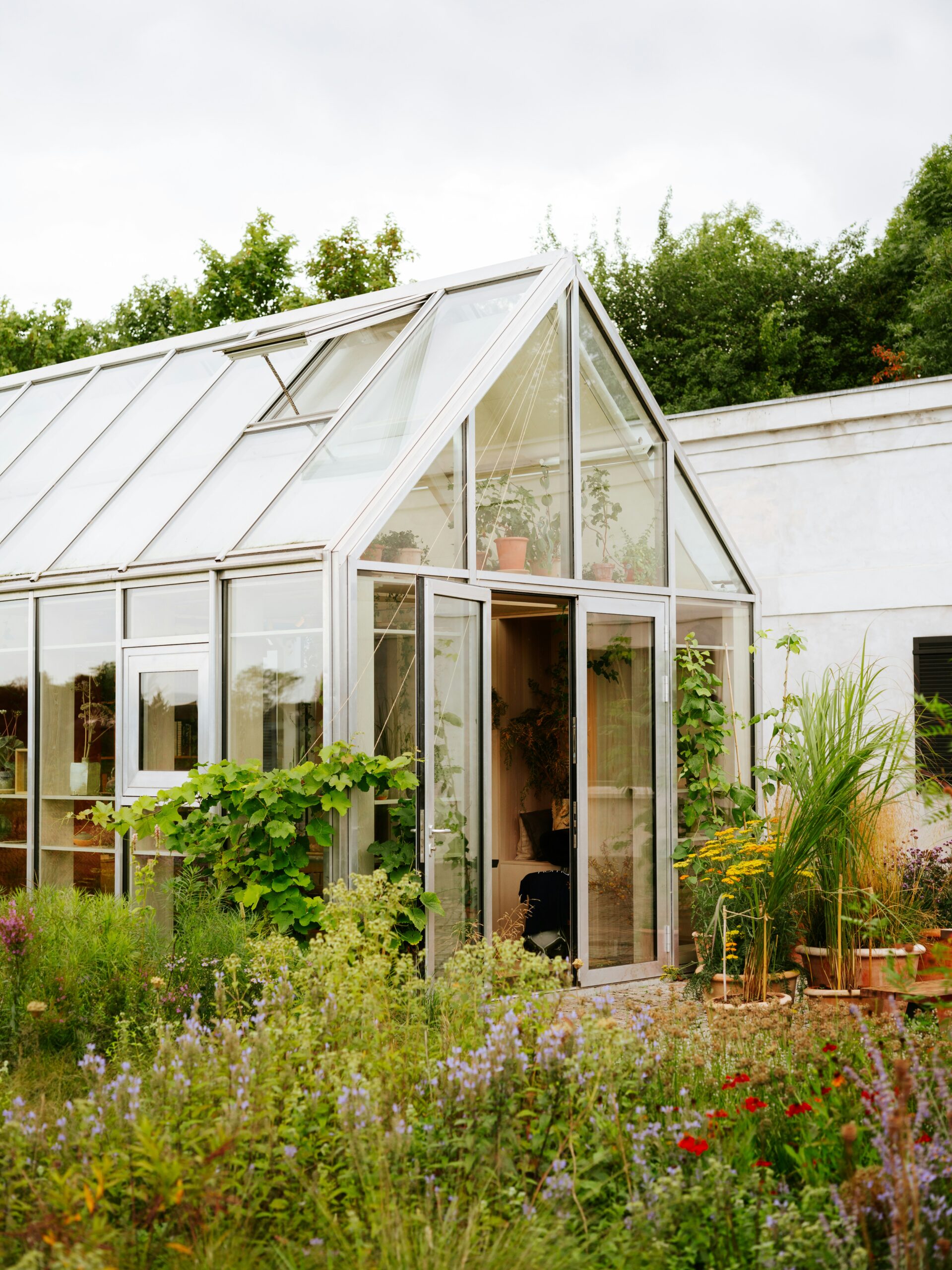 Gardening 101: A Beginner’s Guide to Planting, Growing, and Maintaining a Beautiful Garden a house with a glass roof and a garden in front of it